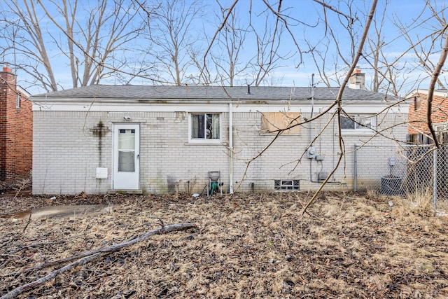 back of property with a chimney and brick siding