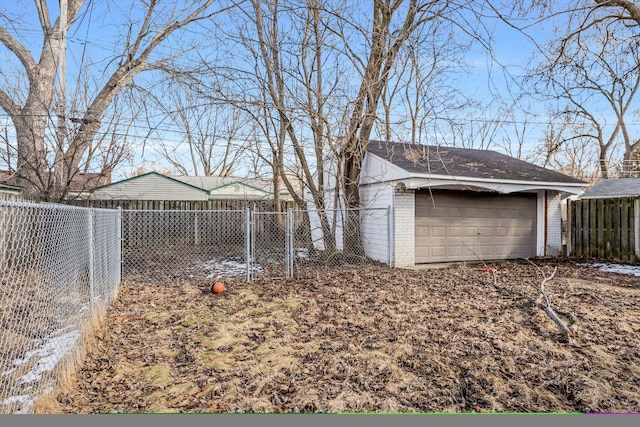 view of yard featuring a garage, a fenced backyard, and an outdoor structure