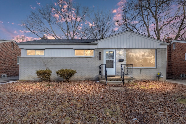 view of front of house featuring brick siding and a chimney