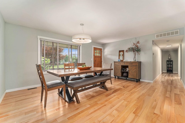 dining area with light wood-type flooring, baseboards, and visible vents