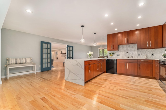 kitchen with pendant lighting, open floor plan, light wood-type flooring, a peninsula, and black appliances