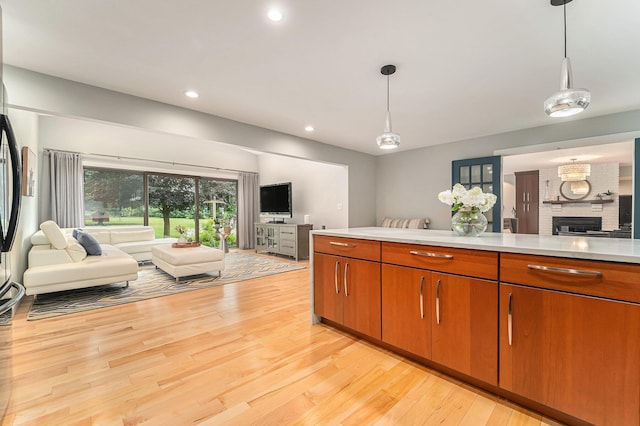 kitchen featuring light wood-style flooring, open floor plan, decorative light fixtures, light countertops, and recessed lighting