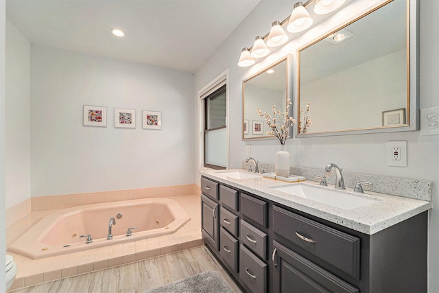 full bathroom with toilet, a sink, a whirlpool tub, and double vanity