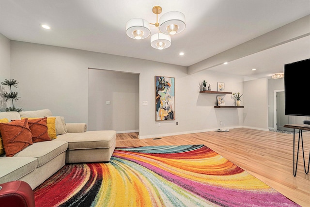 living area with a notable chandelier, baseboards, wood finished floors, and recessed lighting