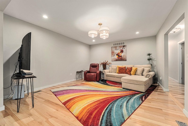 living area with recessed lighting, wood finished floors, visible vents, and baseboards