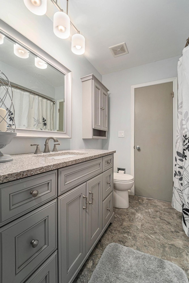 bathroom with visible vents, vanity, and toilet