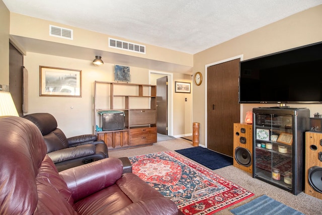 carpeted living area with visible vents, a textured ceiling, and baseboards