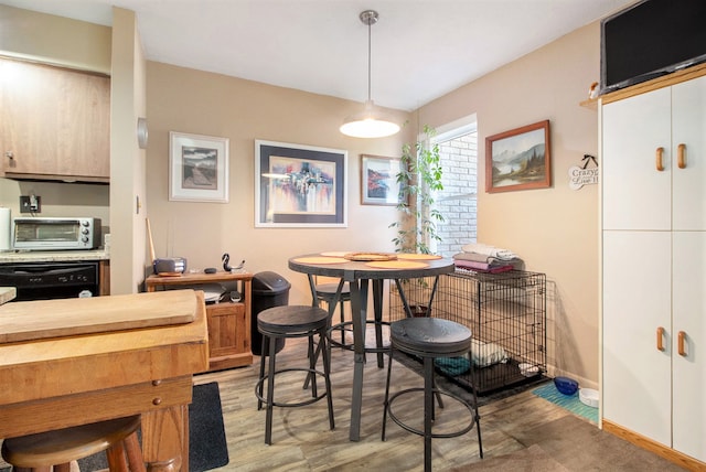 dining space with light wood-style floors, a toaster, and baseboards