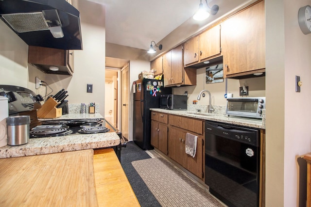 kitchen with extractor fan, a toaster, a sink, light countertops, and black appliances