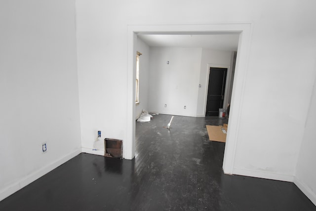 unfurnished room featuring concrete floors and baseboards