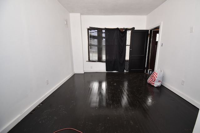 spare room featuring wood finished floors and baseboards