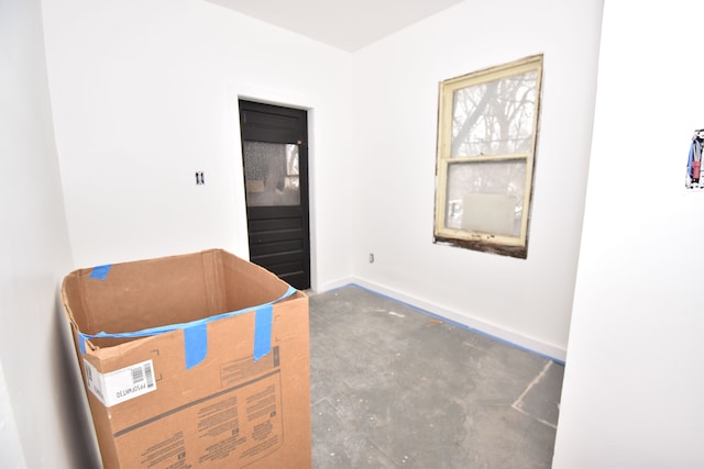 interior space featuring concrete floors and baseboards