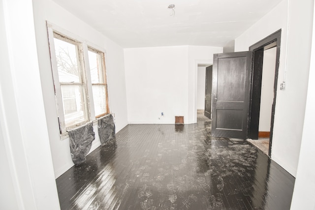 empty room featuring dark wood finished floors and baseboards