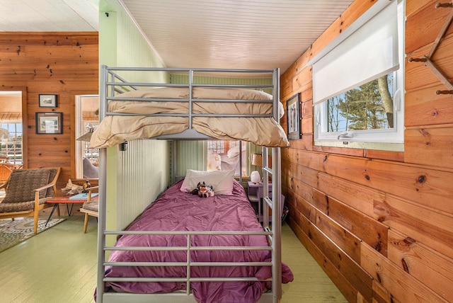 bedroom featuring wood walls and wood finished floors