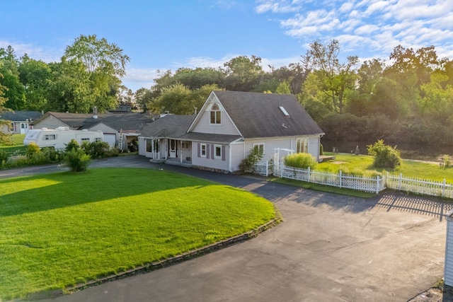 view of front of house featuring driveway, a fenced front yard, and a front yard