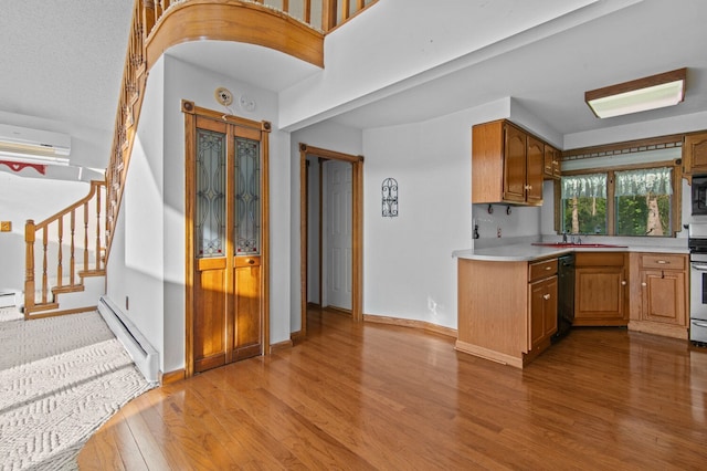 kitchen with light countertops, a baseboard heating unit, brown cabinetry, an AC wall unit, and built in microwave