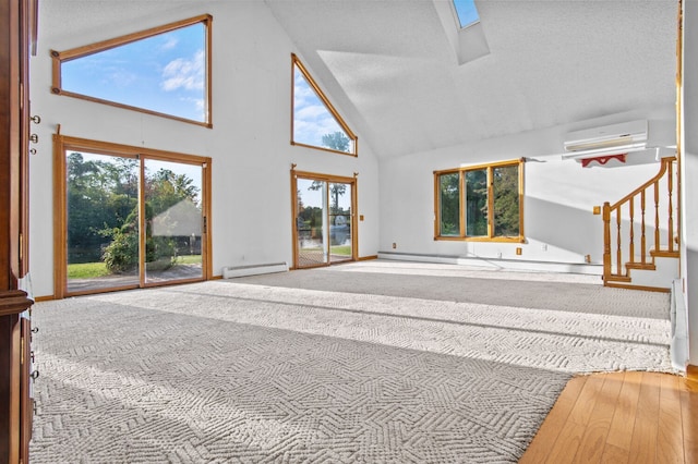 unfurnished living room with a baseboard heating unit, a wall unit AC, high vaulted ceiling, and stairs