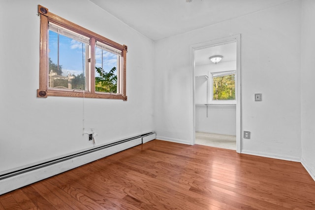 spare room with light wood-type flooring, baseboards, and baseboard heating