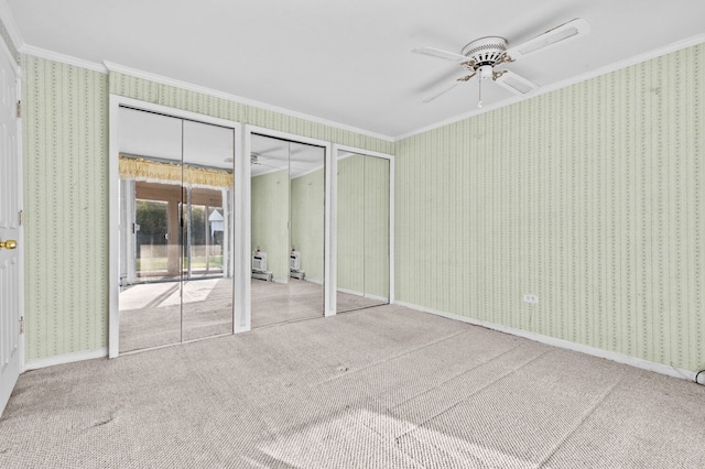 unfurnished bedroom featuring crown molding, carpet floors, and wallpapered walls