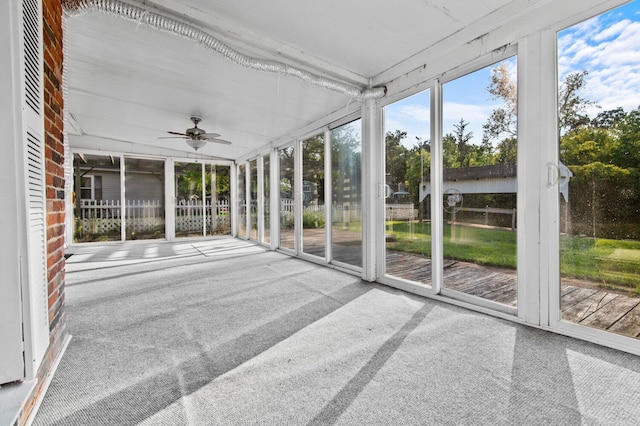 unfurnished sunroom featuring a ceiling fan