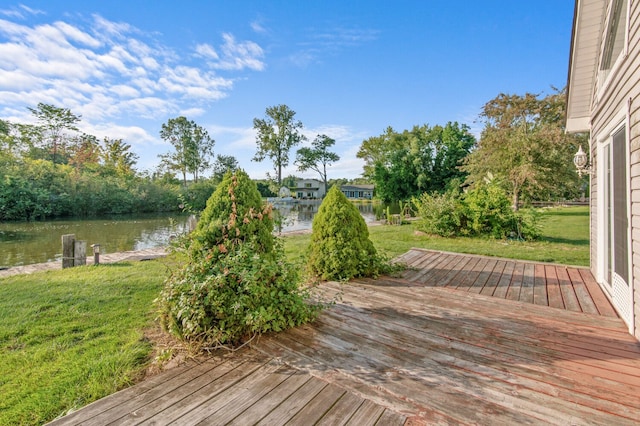 wooden deck with a water view and a yard