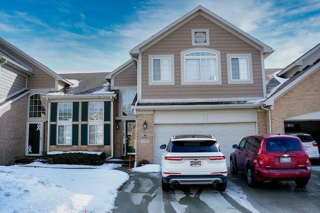 view of front facade with brick siding, driveway, an attached garage, and roof with shingles