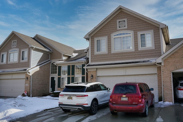 view of front of house with an attached garage, concrete driveway, and brick siding