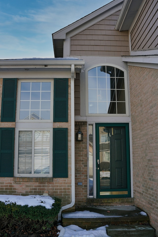 entrance to property featuring brick siding