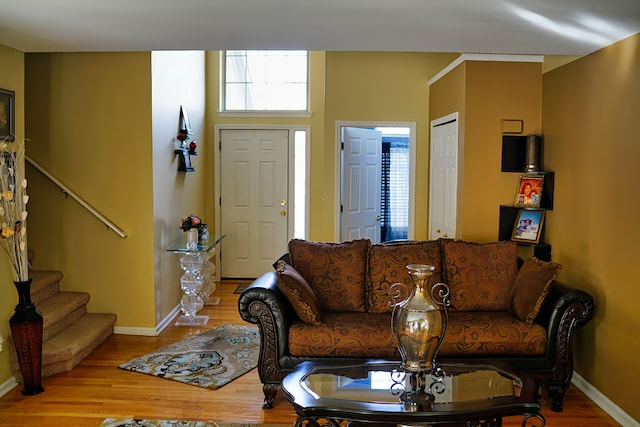 living area featuring stairway, wood finished floors, and baseboards