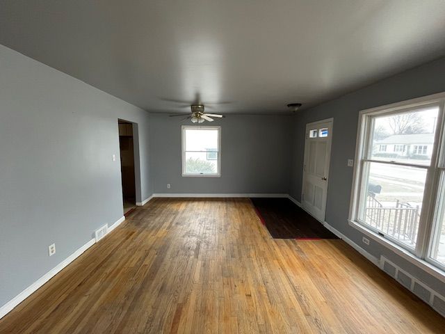 interior space featuring light wood-type flooring, baseboards, visible vents, and a ceiling fan