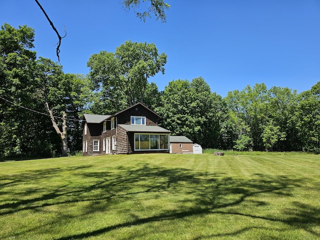 view of front of house with a shed, a front lawn, and an outdoor structure