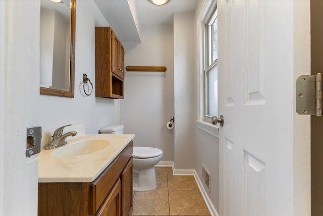 half bathroom with visible vents, toilet, vanity, baseboards, and tile patterned floors