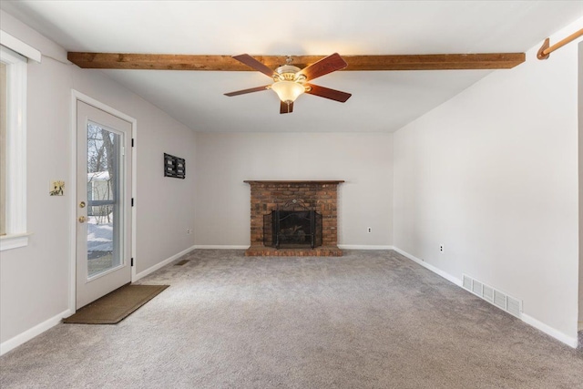 unfurnished living room featuring carpet, beam ceiling, a fireplace, visible vents, and baseboards