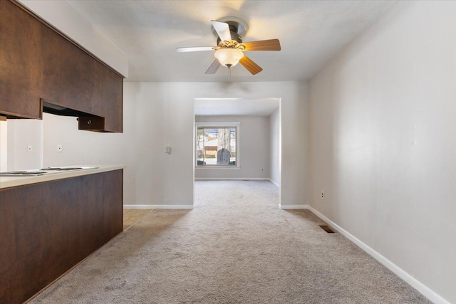 kitchen with visible vents, light countertops, light carpet, and baseboards