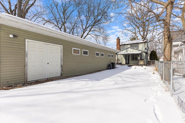 snow covered property with fence