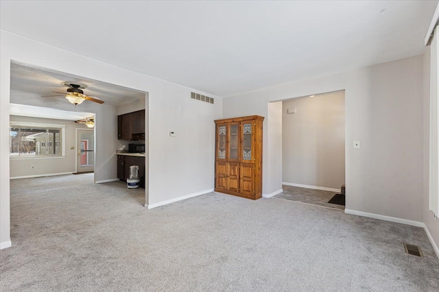 spare room featuring light carpet, baseboards, and visible vents