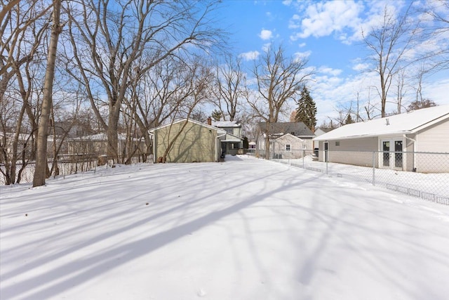 snowy yard featuring fence