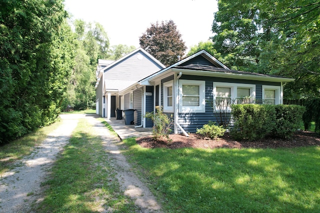 bungalow-style house featuring driveway and a front lawn