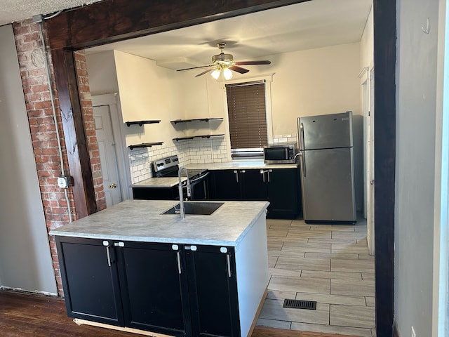 kitchen with dark cabinetry, a ceiling fan, decorative backsplash, light countertops, and appliances with stainless steel finishes