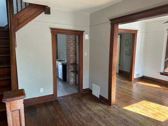 unfurnished living room featuring stairs, baseboards, visible vents, and hardwood / wood-style floors