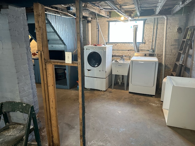 below grade area featuring a sink, fridge, and separate washer and dryer