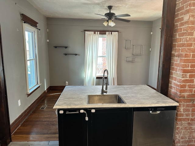 kitchen with visible vents, a sink, stainless steel dishwasher, a textured ceiling, and dark cabinetry