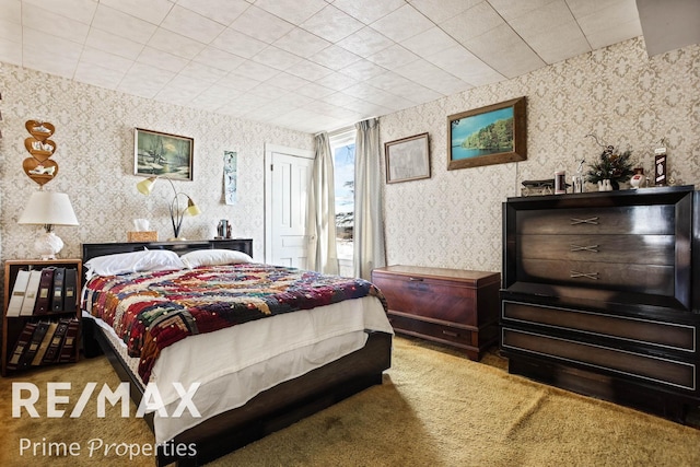 carpeted bedroom featuring a closet and wallpapered walls