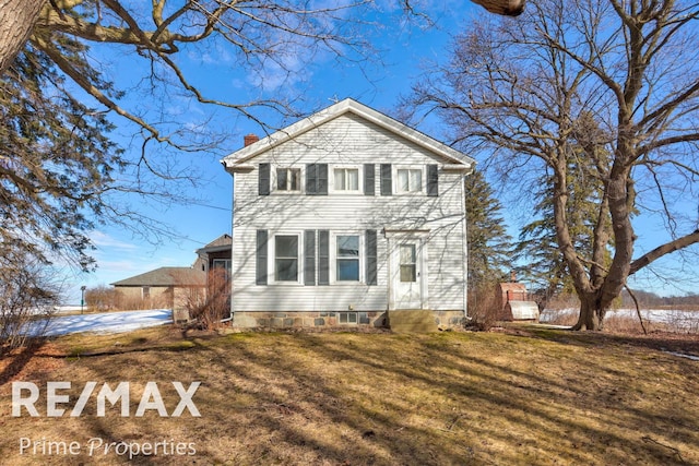 view of front of house featuring a chimney and a front yard