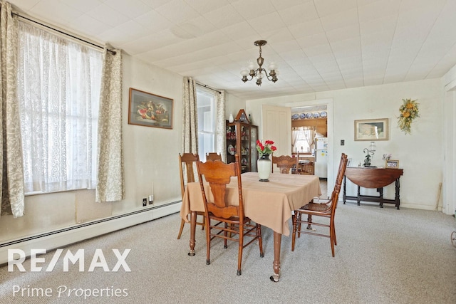 dining room featuring a baseboard heating unit, carpet, and a notable chandelier