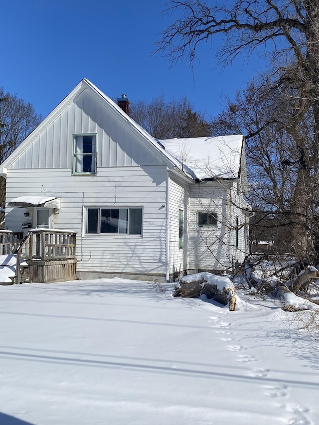 exterior space with board and batten siding and a chimney