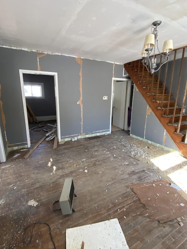 unfurnished living room with stairway and an inviting chandelier