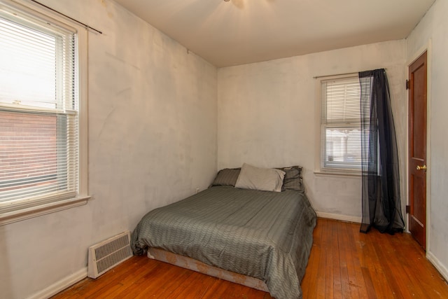 bedroom featuring hardwood / wood-style flooring, visible vents, and baseboards