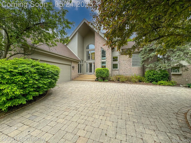 28036 Hickory Cir, Farmington Hills, MI 48331 - mid-century modern home featuring a garage, brick siding, and driveway
