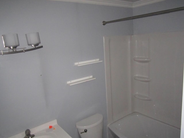 bathroom with toilet,  shower combination, a sink, and ornamental molding